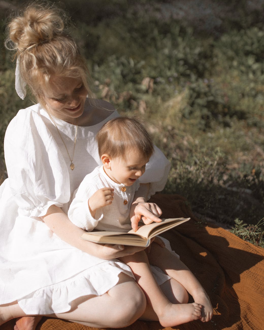 photo of mother and baby reading a book